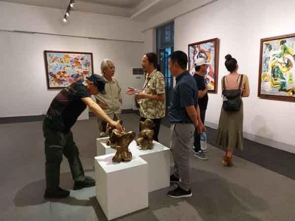 Họa sĩ Trần Lưu Mỹ (giữa) đang trao đổi với các họa sĩ Ca Lê Thắng, Điêu khắc gia Đào Châu Hải và nhà sưu tập Mai Gallery tại triển lãm "Giấc mơ siêu thực". 