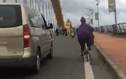 Hình ảnh đẹp: Thấy gió lớn khiến người phụ nữ đi xe đạp chao đảo, tài xế ô tô đi chầm chậm để làm "lá chắn" qua cầu Rồng