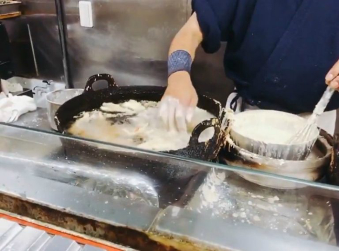 Một đầu bếp Nhật dùng tay không rán bánh trong dầu nóng
