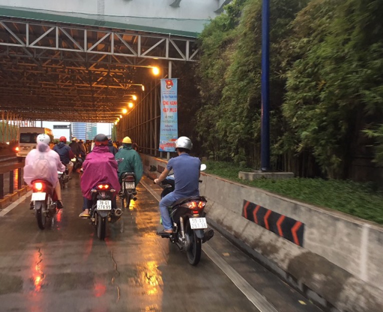 Người dân qua hầm vượt sông Sài Gòn được tặng áo mưa miễn phí